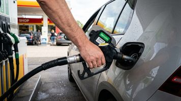Persoon die benzine aan het tanken is.