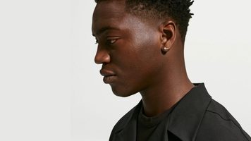 Een man met de oorbellen uit de juwelencollectie van Nike