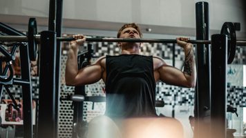 Een man die aan het sporten is in de sportschool