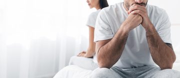 Een man en vrouw die met de rug naar elkaar zitten