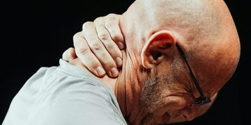 Man met nekpijn (mogelijk door stress)