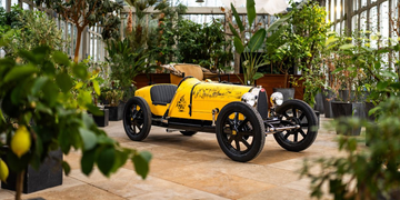 De Bugatti Baby II gefotografeerd in een tuinkas met citroenen en groene bladeren