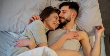Een man en een vrouw samen onder de dekens