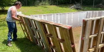 man bouwt zwembad van pallets