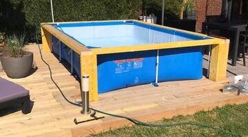 man bouwt platform om zwembad