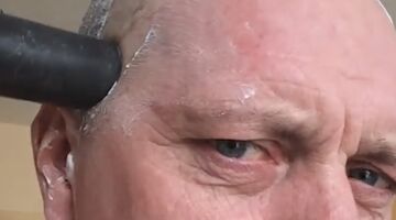 man knipt haren met stofzuiger en haarverwijderaar