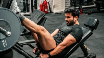 Man in de sportschool die traint, mogelijk gericht op afvallen en het behouden van spiermassa