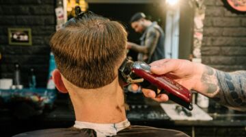 Man zit bij de kapper terwijl hij een kort kapsel met fade krijgt