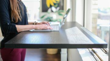 Een vrouw die aan het werken is aan een sta-bureau