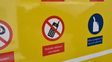 Een bord dat waarschuwt dat je geen mobiele telefoon moet gebruiken bij een tankstation