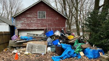 Buitenaanzicht van een huis, welke door de grote rommel minder waard is