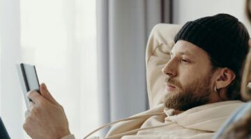 Een man die aan het lezen is, iets wat je kan doen op je vrije dag als je alleen bent
