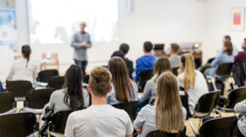 Studenten in een collegezaal aan het luisteren naar hun lector