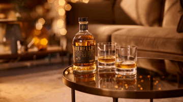 Aberfeldy Golden Dram op een tafel gepositioneerd, samen met whiskyglazen.