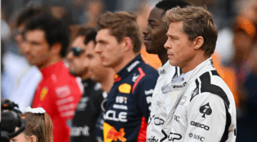 Een shot uit F1: The Movie, met op de voorgrond acteurs Brad Pitt en Damson Idris, en daarachter wat echte coureurs uit de F1 zoals Max Verstappen zelf