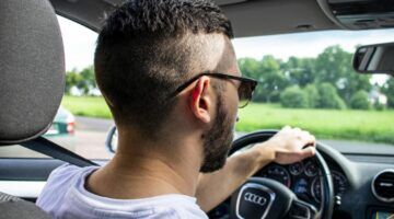 Man achter het stuur van zijn auto van het merk Audi