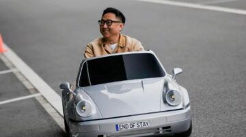 Man die in een mini Porsche rijdt