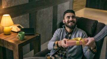 Een man die een cadeau in handen krijgt