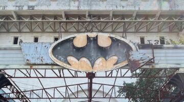 Verwoest Batman-logo boven de ingang van de verlaten nachtclub