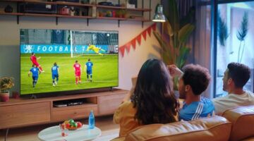 Drie mensen zitten op de bank en kijken tv