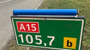 Hectometerpaaltje met een blauwe roller