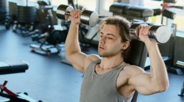 Man aan het sporten in de sportschool (mogelijk is hij ook bezig met een minicut)