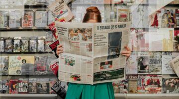 Een vrouw die de krant aan het lezen is