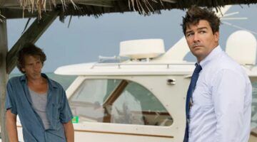 Twee mannen die staan bij een boot