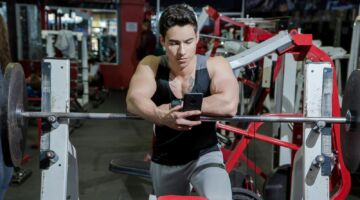 Een man die tijdens het sporten op zijn telefoon zit