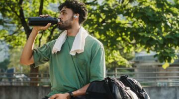 Een gezonde man die net klaar is met hardlopen en nu uit zijn bidon aan het drinken is