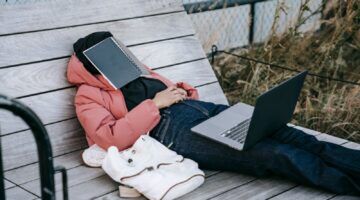 Een persoon die moe op een bank zit