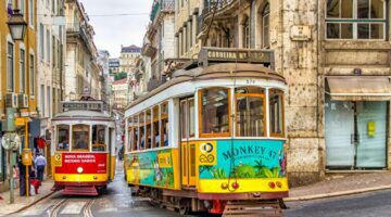 Twee trams die door een stad rijden in Lissabon