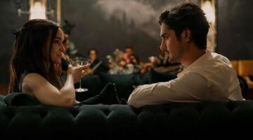 Een man en vrouw die op de bank zitten met een drankje