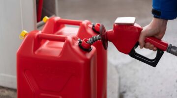 Een man die 2 jerrycans aan het vullen is met benzine