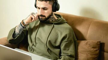 Een man die op zijn laptop bezig is met beleggen