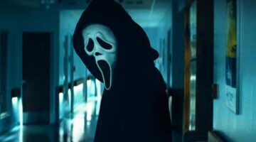 Een persoon met een masker die in een donkere gang staat.