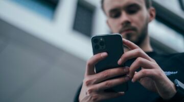 Een man die op zijn telefoon zit.