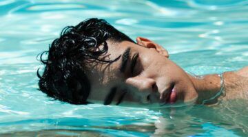Een man die in de zon in het water ligt