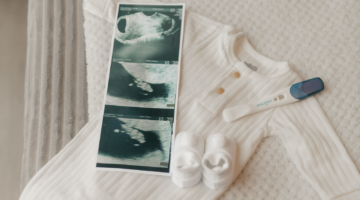 Babykleding, een zwangerschapstest en een ego van een baby neergelegd.