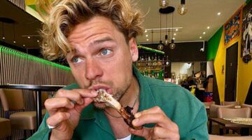 Daan van der Lecq eet een chickenwing.