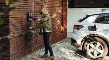 Een man die zijn elektrische auto gaat opladen.