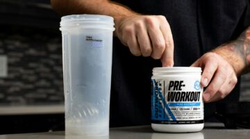Iemand die pre-workout in een beker doet.