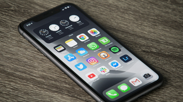 Een telefoon met apps die op tafel ligt.