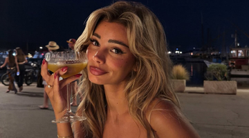 Laura Celia die een glas vast heeft.