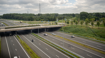 Een nederlandse snelweg, er rijden een paar auto's op de weg