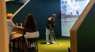 Een man die virtueel aan het golfen is bij Club Birdies in Amsterdam