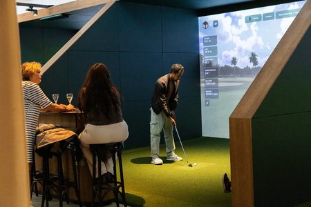 Een man die virtueel aan het golfen is bij Club Birdies in Amsterdam