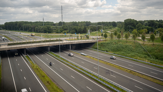 Een nederlandse snelweg, er rijden een paar auto's op de weg