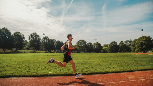 Een man die rent op een atletiekbaan.