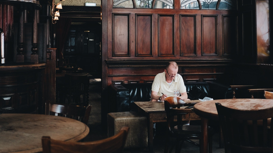 Een man die alleen in een restaurant aan een tafel zit.